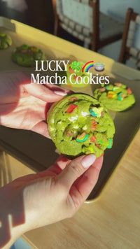 person holding baked matcha cookies
person mixing matcha into cookies mix and ingredients
placing matcha cookies on baking tray
close-up of baked matcha cookies
person breaking matcha cookie to show texture